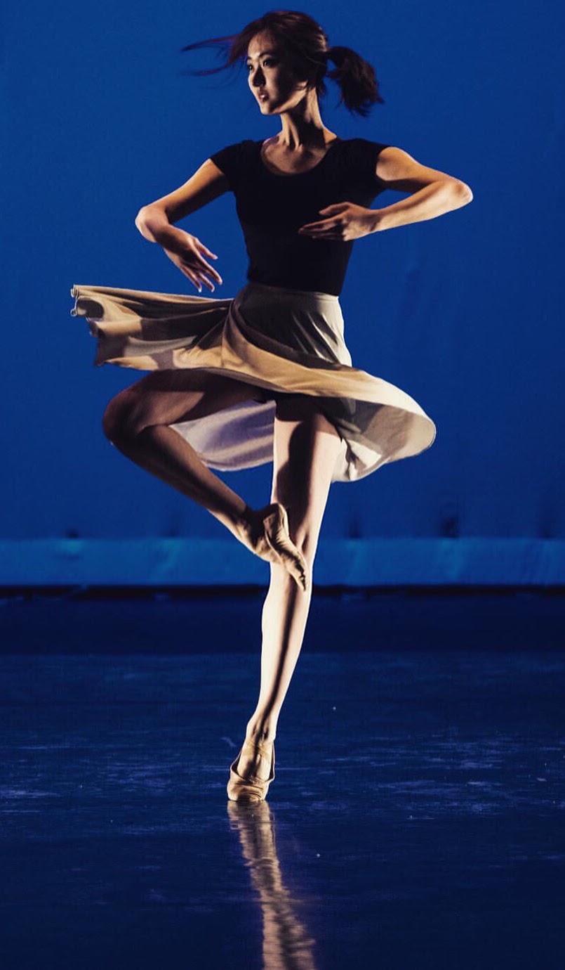 Verina turning on a blue-lit stage